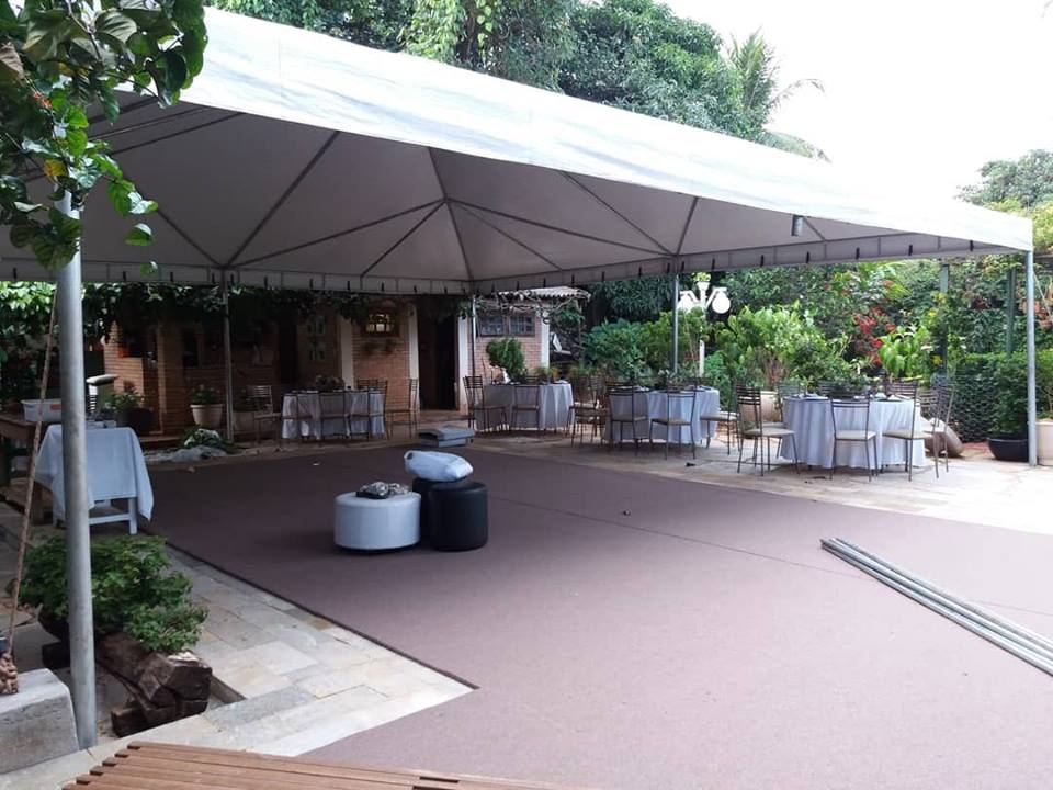 Tenda piramidal da Mestre Tendas montada em jardim com mesas postas para evento